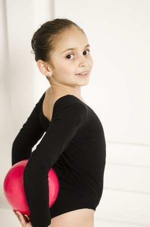 Beautiful sport training rhythmic gymnastic girl posing in studioの写真素材