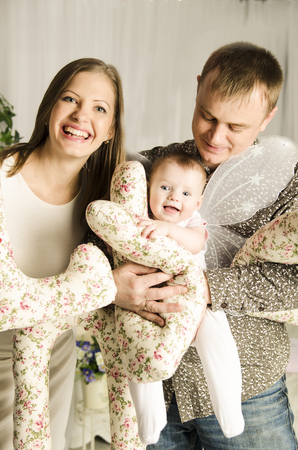Happy family with cute child angel. posing in studioの写真素材