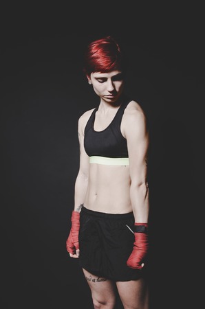 young tattooed woman boxer standing and looking to camera close up portraitの写真素材