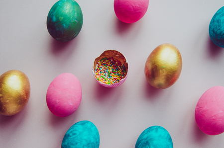 Beautiful colorful easter eggs with confectionery sprinkling on pink background s patternの写真素材