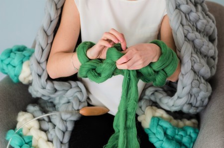 young woman kniting merino wool with hands, close upの写真素材