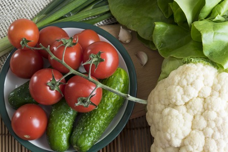 Tomatoes and other vegetables on the tableの写真素材