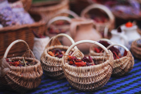 Hand made braided baskets with red chilli peppers on table, outdoor photo from city fair.の写真素材