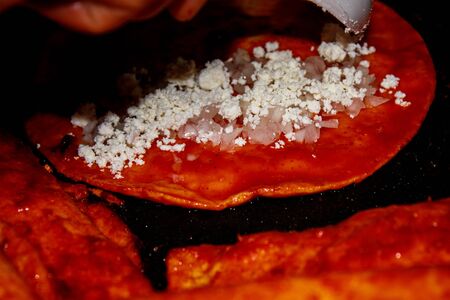Enchiladas. Typical Mexican dish. Omelette soaked in red chili sauce. Served with cheese, cream,...
