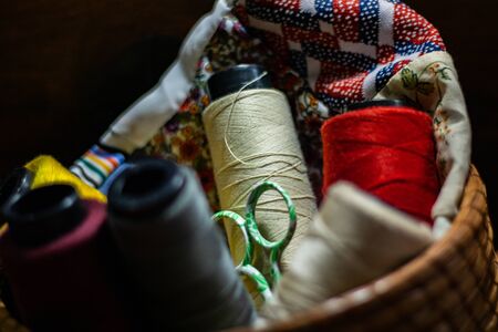 Various colors of thread rolls sits in wooden basketの写真素材