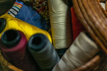 Various colors of thread rolls sits in wooden basketの写真素材