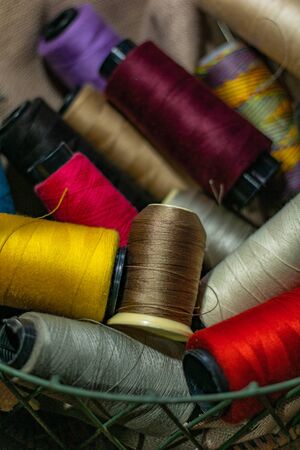 Various colors of thread rolls sits in wooden basketの写真素材