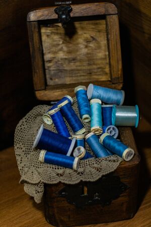 Wooden box with blue threads on a cloth