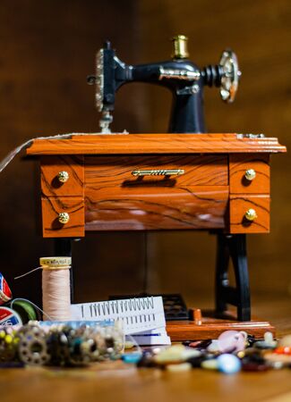Mini sewing machine with multi-colored threads around itの写真素材