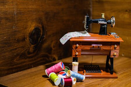Mini sewing machine with multi-colored threads around itの写真素材