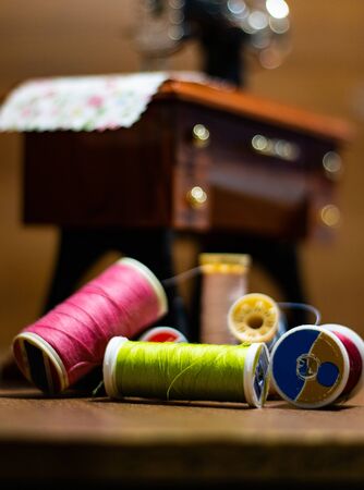 Mini sewing machine with multi-colored threads around itの写真素材