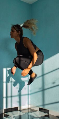 Latin woman doing yoga workout in her house / indoorsの写真素材