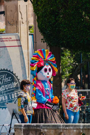 MORELIA, MEXICO - OCTOBER 31, 2020: Young people dressed in colonial-era costumes selling tickets...