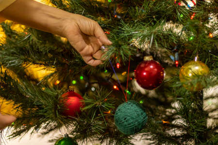 Close up view of a hand of an old woman decorating the christmas treeの写真素材