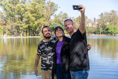 Group of friends of different ages taking a selfie in a lake. Happy expressions. copy-space