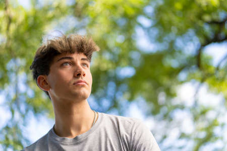 Confident young blonde man portrait, summer trees background. copy-spaceの写真素材