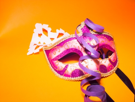 carnival mask and handmade paper snowfakes on orange backgroundの写真素材