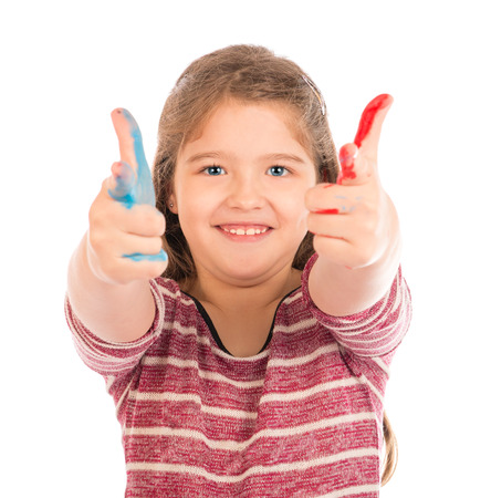 Cute little girl playing with red and blue paint, pointing with both hands at the cameraの写真素材