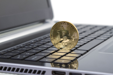 Studio shot of golden Bitcoin virtual currency on laptop. Close-up of front side. の写真素材