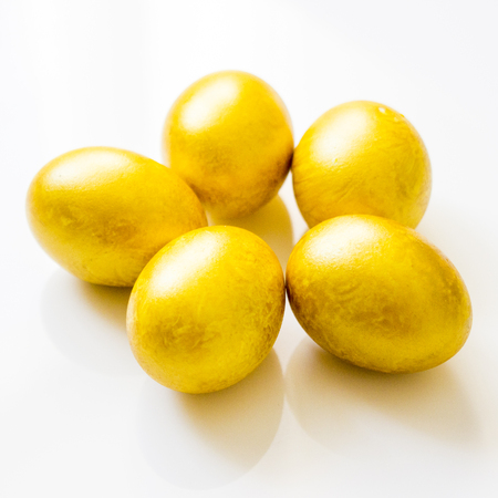 Five gold easter eggs on the tableの写真素材