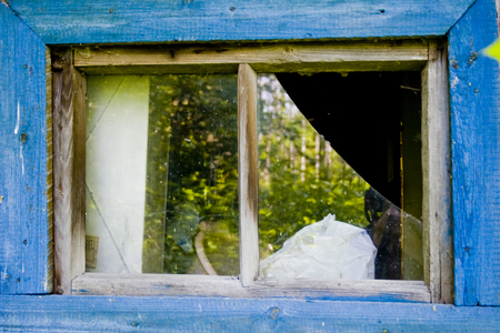 broken window of a house in blue frameの写真素材