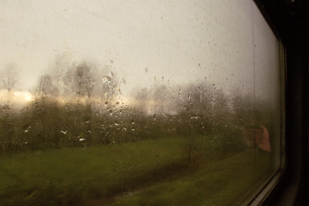 Landscape through a wet window with raindrops