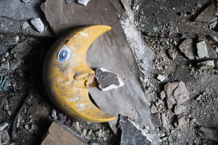 Yellow moon of plastic on dirty floor with pieces of joke and concreteの写真素材