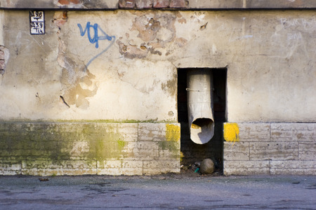 Drainpipe in the wall in the rays of the sunの写真素材