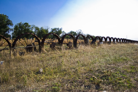Fence and fence of old wheels on the fieldの写真素材