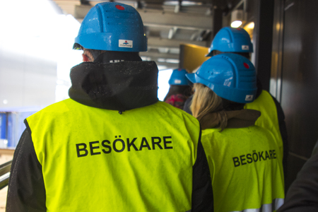 Workers in yellow jackets and helmets in Sweden view from the backの写真素材