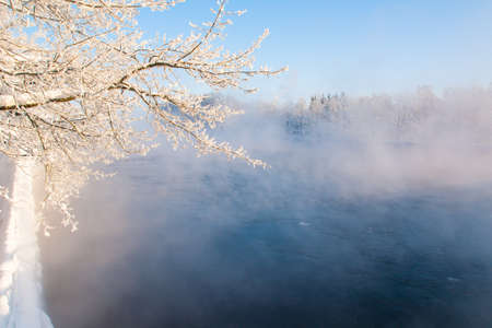 Fog winter landscape on the river Fabulous misty view of lake Frosty morning. Cold weather background concept. Abstract minimalistic picture. Christmas and New Year holiday greeting cardの写真素材