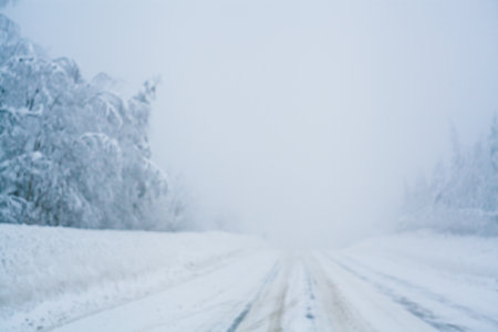 Winter blizzard in the driving north empty road landscape with white trees and snow with fog in the background. Road trip concept. Trees and roadside in snow. Christmas photo with copy spaceの写真素材