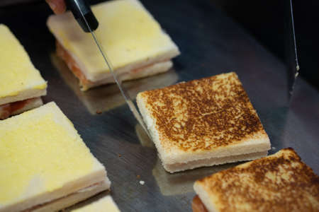 Grilled and pressed toasts with smoked ham and cheese served on a tray.