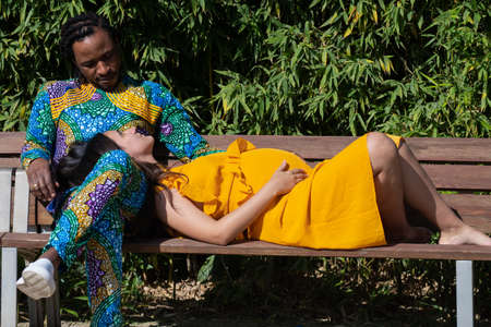 Mixed race couple posing for maternity shoot in a park.の写真素材