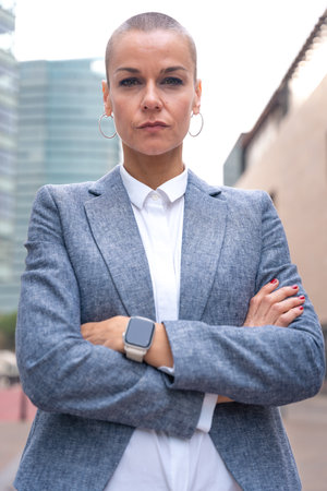 Vertical portrait of serious businesswoman looking at camera outdoors.の写真素材