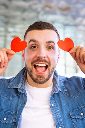 Vertical portrait smiling young woman holding hearts on Valentines Day outdoorsの写真素材