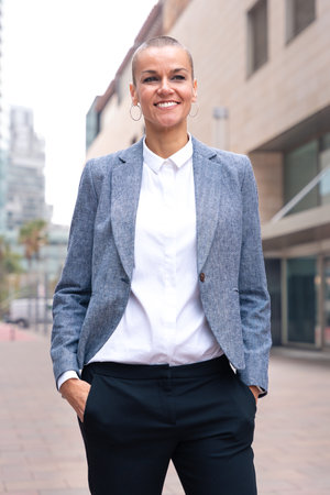 Vertical portrait of a smiling businesswoman looking at the camera outdoors.の写真素材