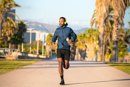 Sportsman running through the streets of the city, holding a bottle of water.