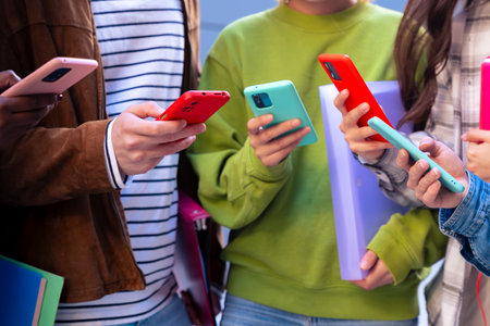 unrecognizable students having fun with mobile phones creating content on social media.