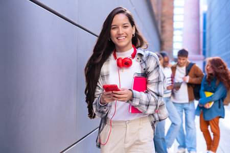 Young latin woman browsing the internet using mobile device outdoors.