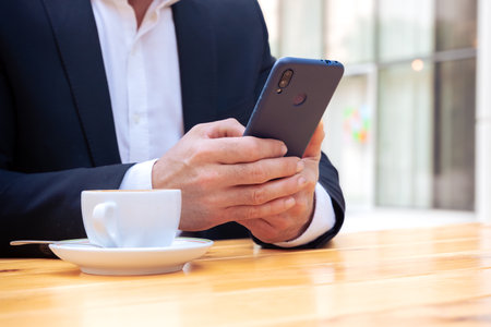 Unrecognizable businessman using an app on his smartphone and standingの写真素材