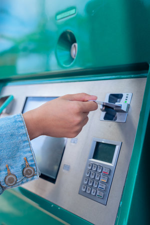 Unrecognizable girl buying tickets at an automatic machine, she is touching the touch screenの写真素材