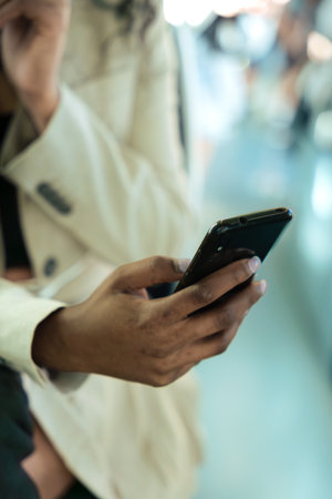 Unrecognizable woman browsing the internet using mobile device outdoors.の写真素材