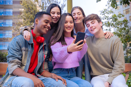 Students having fun with mobile phones creating content on social media.の写真素材