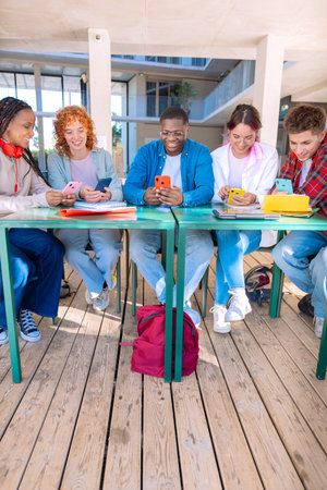 Five happy multiracial students studying with smartphones outdoors.Verticalの写真素材