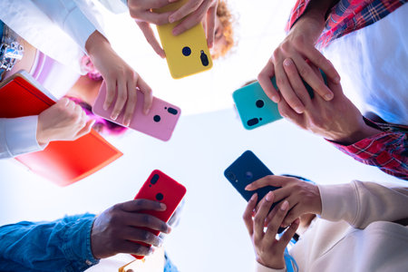 Group of people holding colorful smartphones in a circleの写真素材