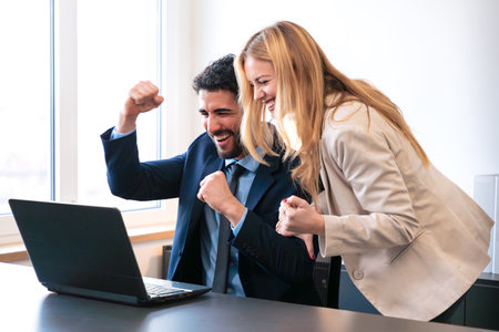 Excited Business Team Celebrating Success in Office Environmentの写真素材