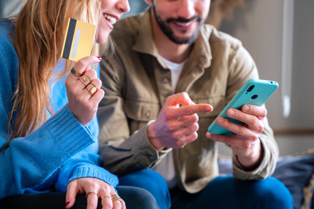 Happy Couple Shopping Online with Smartphone and Credit Cardの写真素材