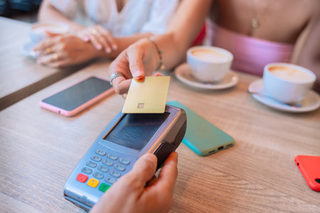 Woman Making Contactless Payment with Credit Card in a Cafe