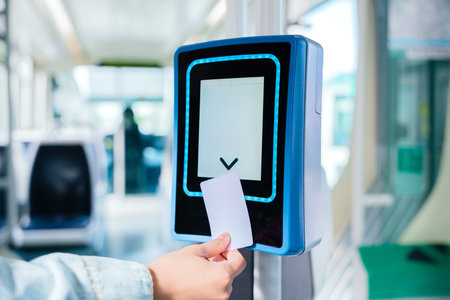 Hand Validating Ticket on Electronic Scanner Inside Public Transportの写真素材